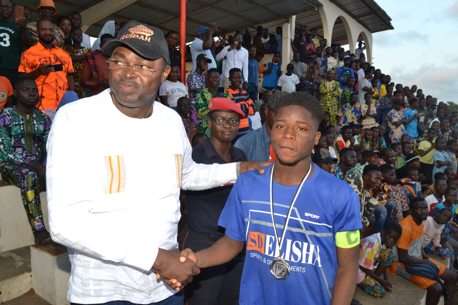 Poignée de main officielle entre un responsable et un joueur récompensé pendant la 5e édition.